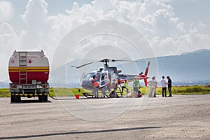 People refueling helicopter.