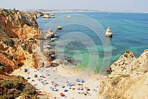 People relax at Praia da Dona Ana beach in Lagos, Portugal.