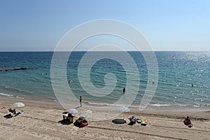 People relax on the sandy beach of Playa de Aguamarina, province of Alicante, Spain photo