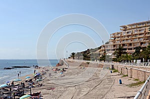 People relax on the sandy beach of Playa de Aguamarina, province of Alicante, Spain photo