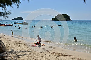 People relaxing on the beach. Tourists come and play the sea.