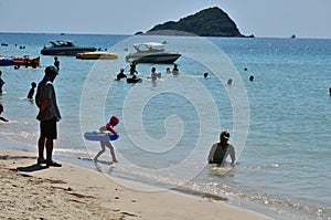 People relaxing on the beach.Tourists come and play the sea.