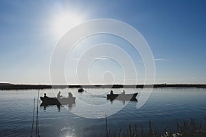 People relaxing at Comana lake, cruising with boats.