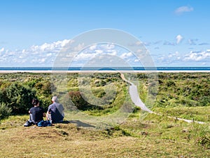 People relaxing in dunes and footpath to North Sea beach on Schiermonnikoog, Netherlands photo