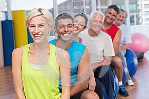 People relaxing on exercise balls in gym class