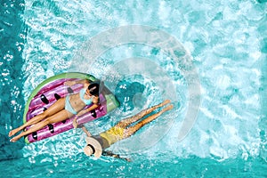 People relaxing on inflatable lilo in hotel pool