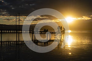 People relaxing at a pier during sunset