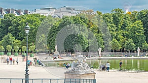 People relaxing in Tuileries Palace open air park near Louvre museum timelapse. Paris, France