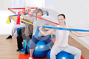 People with resistance bands sitting on fitness balls