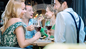 People in a restaurant eating and drinking red wine