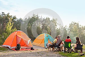 People resting near camping tent