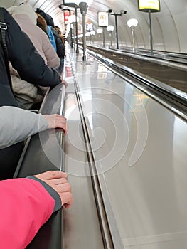 People ride a long escalator in the subway