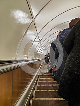 People ride a long escalator in the subway
