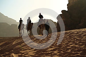 People rides on camels in Wadi Rum desert in Jordan