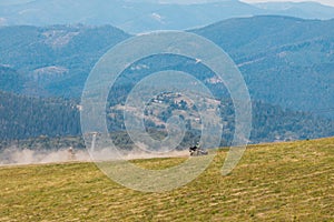 people riding on all terrain vehicle by mountains