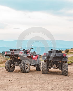 people riding on all terrain vehicle by mountains