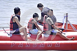 People riding on a banana boat in bali beach