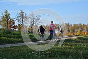 People riding on a bikes on a rural road autumn landscape Minsk city Belarus