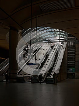 People riding the escalators inside of the Canary Wharf underground tube station