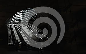 People riding the escalators inside of the Canary Wharf underground tube station