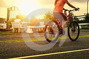 People riding exercise bikes at the park in the evening