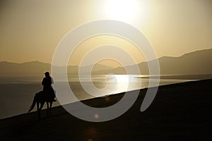 people riding horse at sunrise