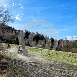 People riding quads on a hill in a sunny beautiful day