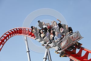 People riding roller coaster