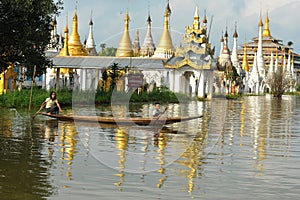 People rowing boat on Inle lake with pagoda background in Shan, Myanmar