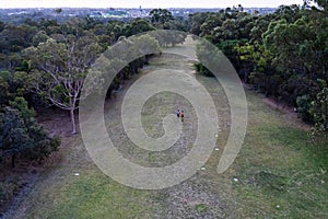 People running at the park with the city at the background. Sports in the nature in the evening. Kings Park and Botanic Garden,