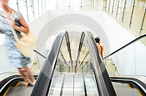 People rush on escalator motion blurred