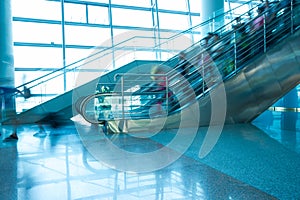 People rush on escalator motion blurred