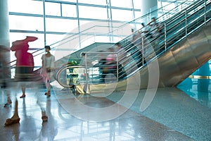 People rush on escalator motion blurred