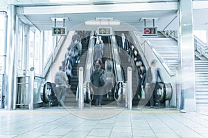 People rush on a escalator motion blurred