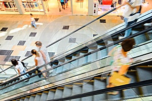 People rush on escalator motion blurred