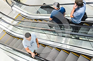 People rush on escalator motion blurred