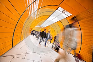 People rushing through a subway corridor