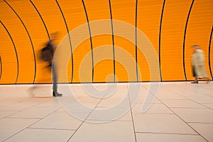 People rushing through a subway corridor