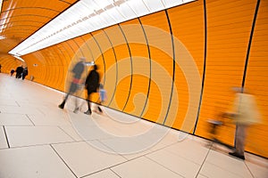 People rushing through a subway corridor