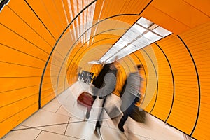 People rushing through a subway corridor photo