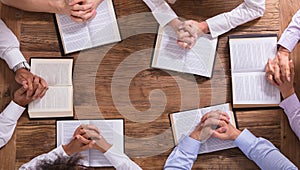 People`s Praying Hands On Holy Bible