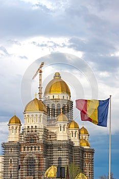 People\'s Salvation Cathedral under construction in Bucharest, with Romanian flag waving in next to it.