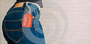 People, sale, consumerism concept. Close up cropped photo of sexual woman`s buttocks wearing blue casual denim pants on gray bric