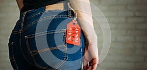 People, sale, consumerism concept. Close up cropped photo of sexual woman`s buttocks wearing blue casual denim pants on gray bric