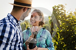 People sampling and tasting wines in vineyard