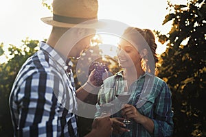People sampling and tasting wines in vineyard
