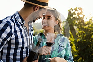 People sampling and tasting wines in vineyard