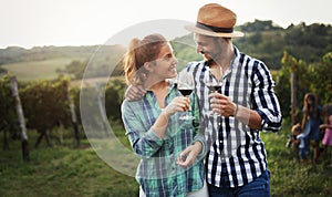 People sampling and tasting wines in vineyard