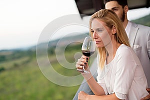 People sampling and tasting wines in vineyard