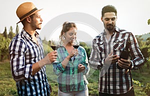 People sampling and tasting wines in vineyard